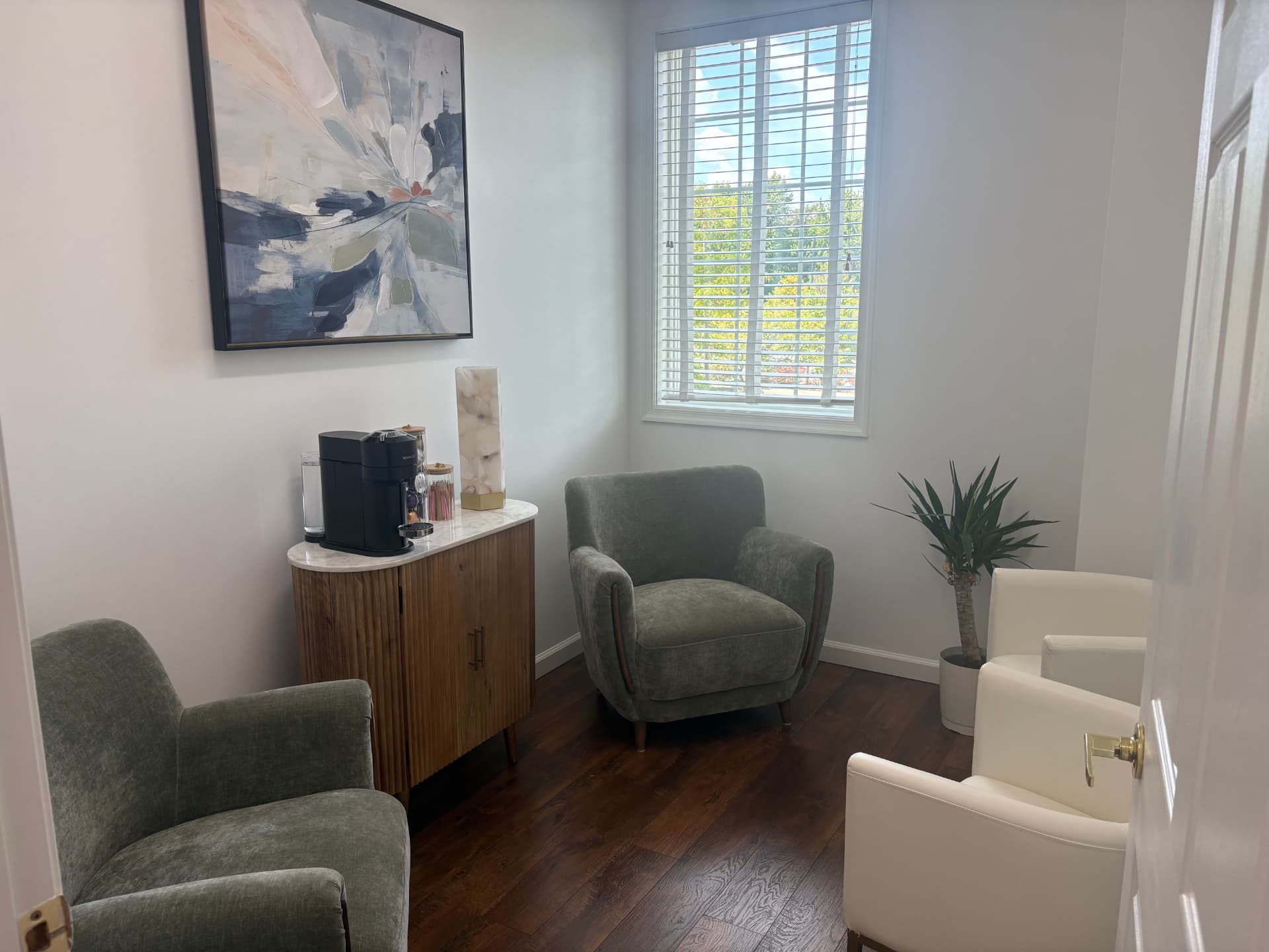Calm consultation lounge at Flourish Medical with soft seating, wood accents, and natural light